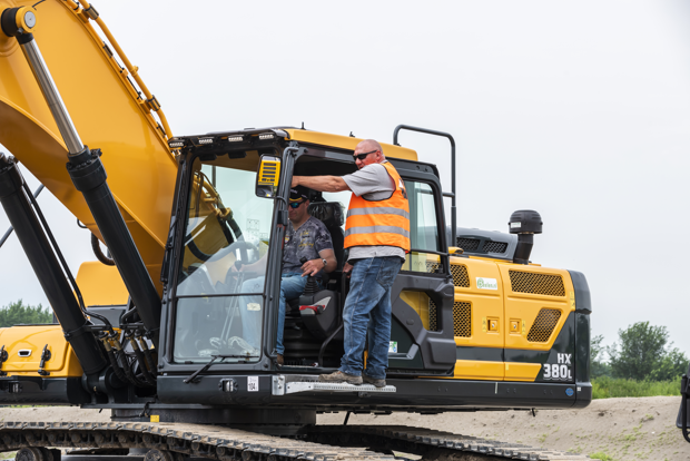 Twee mannen op een graafmachine