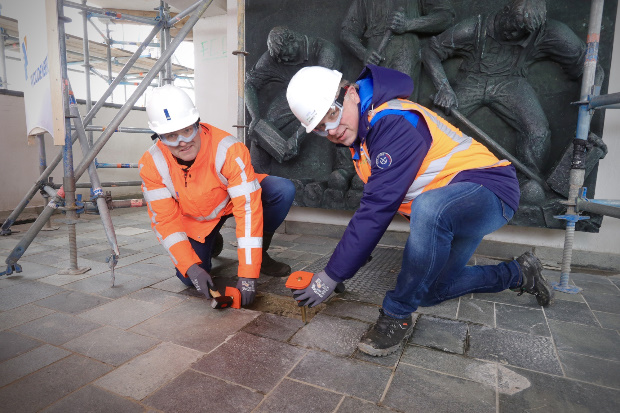 Projectmanager Afsluitdijk Wop Schat en gedeputeerde van Noord Holland Cees Loggen verwijderen de eerste oude tegels.