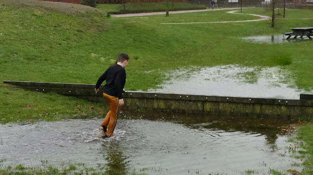 Jongen die speelt in een plas